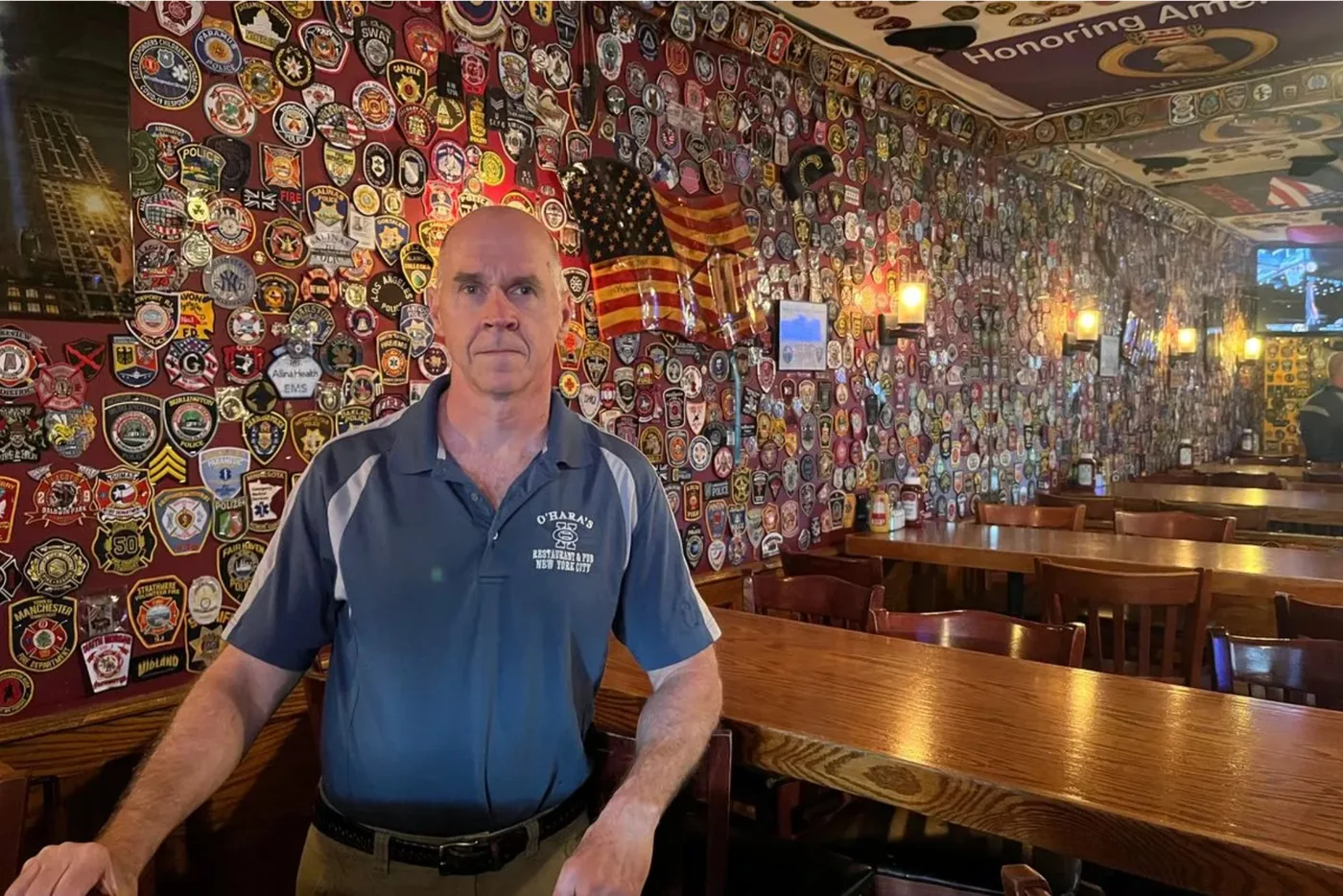 Bar owner in front of the patch wall